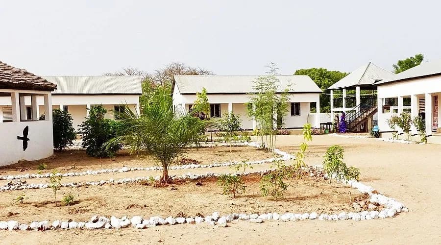 Whitewashed rooms around a sandy courtyard at Morgan Kunda Lodge